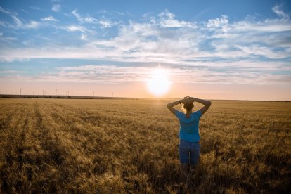 Una mujer disfruta en el campo de un día soleado.