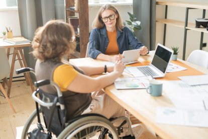 Una persona con discapacidad con una compañera en una oficina.