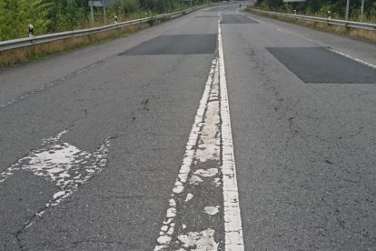 Tramo de carretera con firme y marcas viales en mal estado.