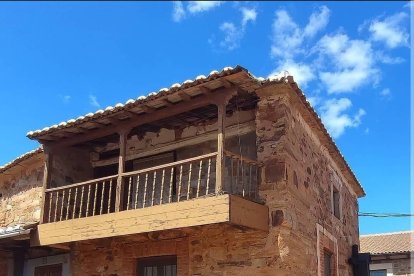 Antigua casa arriera de Castrillo de los Polvazares con balcón de madera y ruedas de carro.