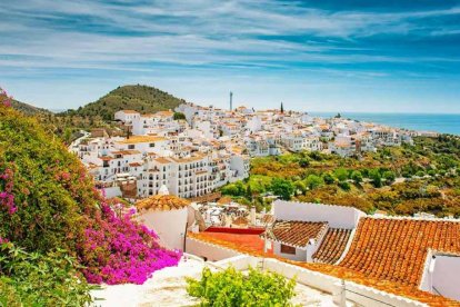 Frigiliana se asoma al Mediterráneo como un balcón blanco salpicado de flores y tejados rojizos, en pleno corazón de la Axarquía malagueña.