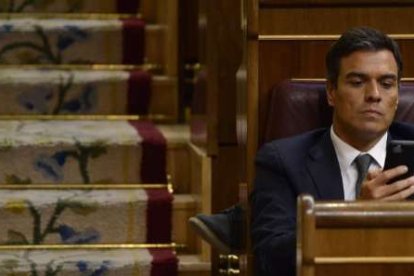 Pedro Sánchez mira el móvil