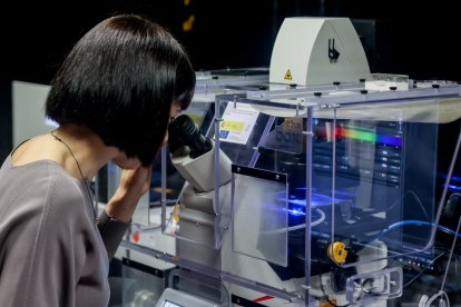 La ministra de Ciencia e Innovación, Diana Morant, mira por un microscopio en su visita al Centro Nacional de Investigaciones Oncológicas (CNIO).