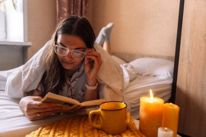 Mujer leyendo libros en la cama