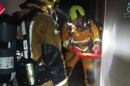 Momento en que los bomberos rompen la puerta de una de las estancias del hostal.
