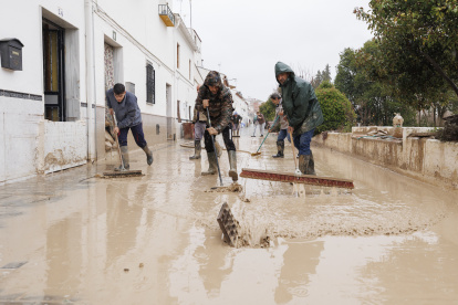 Vecinos de Villanueva Mesía (Granada) se afanan en sacar el agua y barro de sus casas tras la crecida del Río Genil.