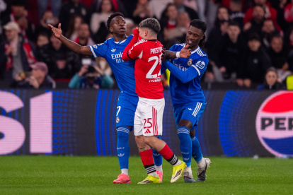 Vinicius en el partido Benfica-Real Madrid mientras Prestianni se tapa la boca con la camiseta.