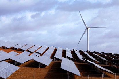 Campo con placas solares y un molino