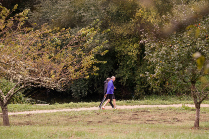 Dos personas caminan por un parque en Lugo, Galicia.