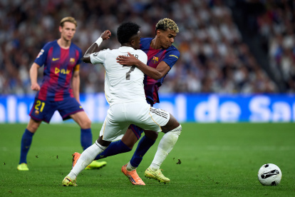 MADRID, SPAIN - OCTOBER 26: Lamine Yamal of FC Barcelona battles for possession with Vinicius Junior of Real Madrid during the LaLiga EA Sports match between Real Madrid CF and FC Barcelona at Estadio Santiago Bernabeu on October 26, 2025 in Madrid, Spain. (Photo by Angel Martinez/Getty Images)