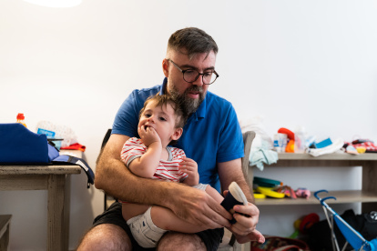 Un padre ayuda a su hijo a vestirse