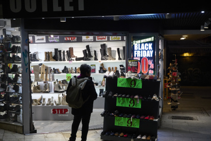 Varias personas pasan por delante de los comercios que anuncian los descuentos del Black Friday. 
Jesús Hellín / Europa Press
23/11/2022