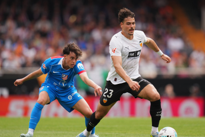 VALENCIA, SPAIN - MAY 02: Filip Ugrinic of Valencia CF is challenged by Javier Bonar of Atletico de Madrid during the LaLiga EA Sports match between Valencia CF and Atletico de Madrid at Estadi de Mestalla on May 02, 2026 in Valencia, Spain. (Photo by Alex Caparros/Getty Images)
