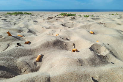 Colillas abandonadas sobre la arena de una playa.