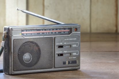 Old transistor radio on wooden background.