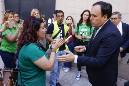 El president de la generalitat Valenciana, Juanfran Pérez Llorca (d), habla con representantes de docentes a la salida de una sesión de control.