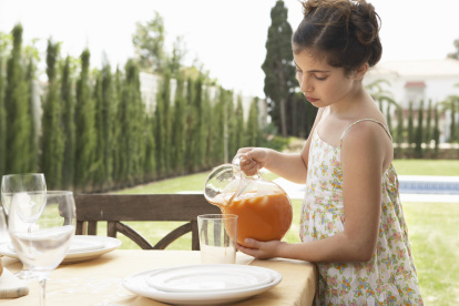 Una niña vierte gazpacho en una jarra