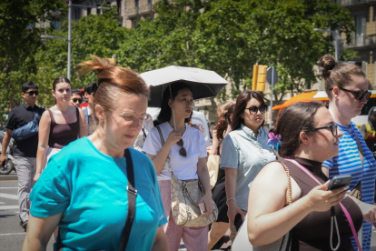 Varias personas se protegen del sol durante una jornada de altas temperaturas provocada por la ola de calor.