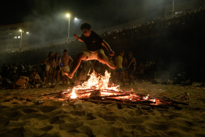 (Foto de ARCHIVO)
Un joven salta una hoguera en la playa durante la Nit de Sant Joan.