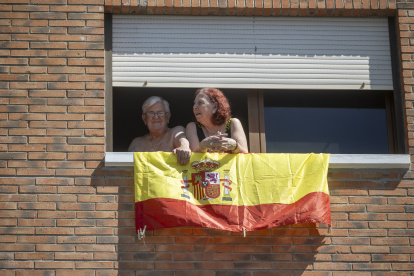 Dos vecinos de Ceuta observan desde su ventana una concentración de embarcaciones y motos en apoyo al pueblo ceutí, a 30 de agosto de 2026, en Ceuta