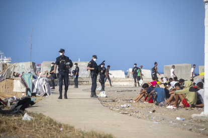 Varios agentes de Policía Nacional controlan a los migrantes en la playa de Trampolín, a 19 de septiembre de 2026, en Ceuta (España). Más de 2.000 personas migrantes han regresado a los asentamientos en las playas ceutíes del Trampolín y de Benítez tras completarse la capacidad del dispositivo provisional de acogida instalado en el puerto de la ciudad. Hasta el traslado de este viernes 18 de septiembre se estimaba que más de 4.000 personas en situación irregular habitaban las chabolas de las playas. De ellas, solo 1.700 han podido ser acogidas en el campamento de Muelle de Poniente, el resto ha vuelto a las playas.

Marcos Moreno / Europa Press
19 SEPTIEMBRE 2026;MIGRANTES;INMIGRACIÓN;INVASIÓN;CRISIS MIGRATORIA;CRISIS HUMANITARIA;POLICÍA
19/9/2026