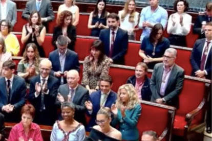 Grezzi sentado mientras todo el hemiciclo aplaude al presidente de Ceuta, Juan Jesús Vivas, cuando la alcaldes, María José Catalá, le ha entregado la Medalla de Honor de la ciudad