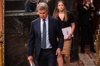 El presidente del PP, Alberto Núñez Feijóo, a su salida de una sesión plenaria en el Congreso de los Diputados. Detrás la portavoz del PP en el Congreso, Ester Muñoz.