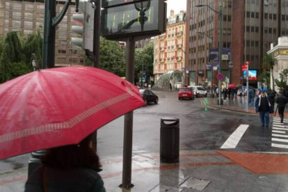 Una persona refugiada bajo un paraguas de la lluvia