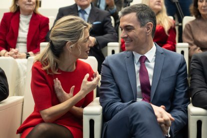 Yolanda Díaz y Pedro Sánchez charlan en un acto.
