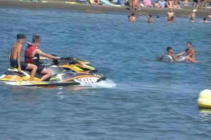Pasajeros en moto acuática sin chaleco salvavidas en una playa de Málaga