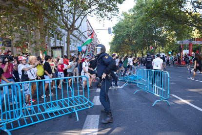 Un agente de Policía Nacional entre vallas tiradas tras cargas policiales a manifestantes que han protestado en favor de Palestina durante la última etapa de la Vuelta a España.