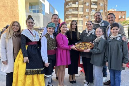 Miembros de la comisión fallera de La Plaza de Torrent muestran una cazuela de 