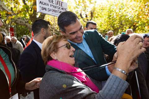 Pedro Sánchez se fotografía con una mujer en un mitin del PSOE en 2022.