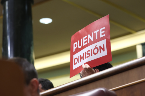 Cartel pidiendo la dimisión del ministro de Transportes, Óscar Puente, durante un pleno en el Congreso de los Diputados.