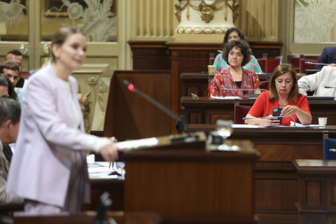 La presidenta del PP de las Islas Baleares, Marga Prohens, interviene durante una segunda sesión de investidura con Armengol de fondo, con el móvil.