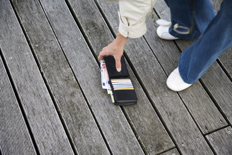 Alguien recoge una cartera del suelo