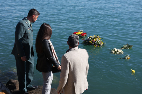 Familiares de los dos guardias civiles muertos en Barbate hacen una ofrenda floral en el puerto.