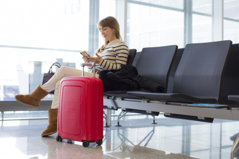 Una mujer espera sentada en el aeropuerto