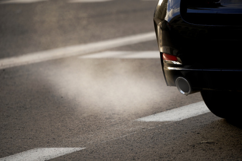 Detalle del tubo de escape de un coche y del humo contaminante