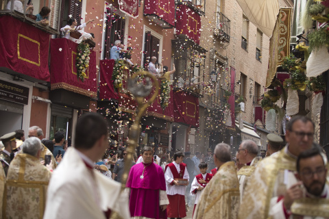 Varias personas observan la procesión de la Custodia de Arfe durante la celebración del Corpus Christi.