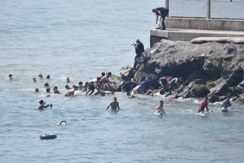 Varias personas intentan cruzar la frontera a nado, a 30 de julio de 2026, en Ceuta