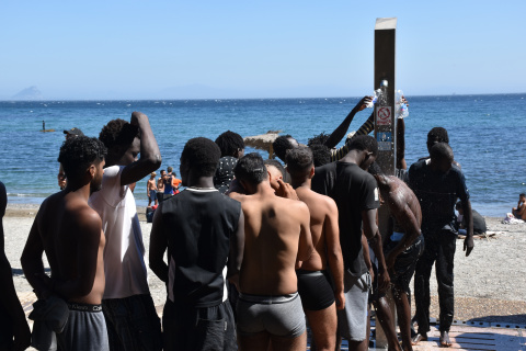 Varias personas se asean en las duchas públicas, en la playa del Trampolín, a 5 de agosto de 2026, en Ceuta.