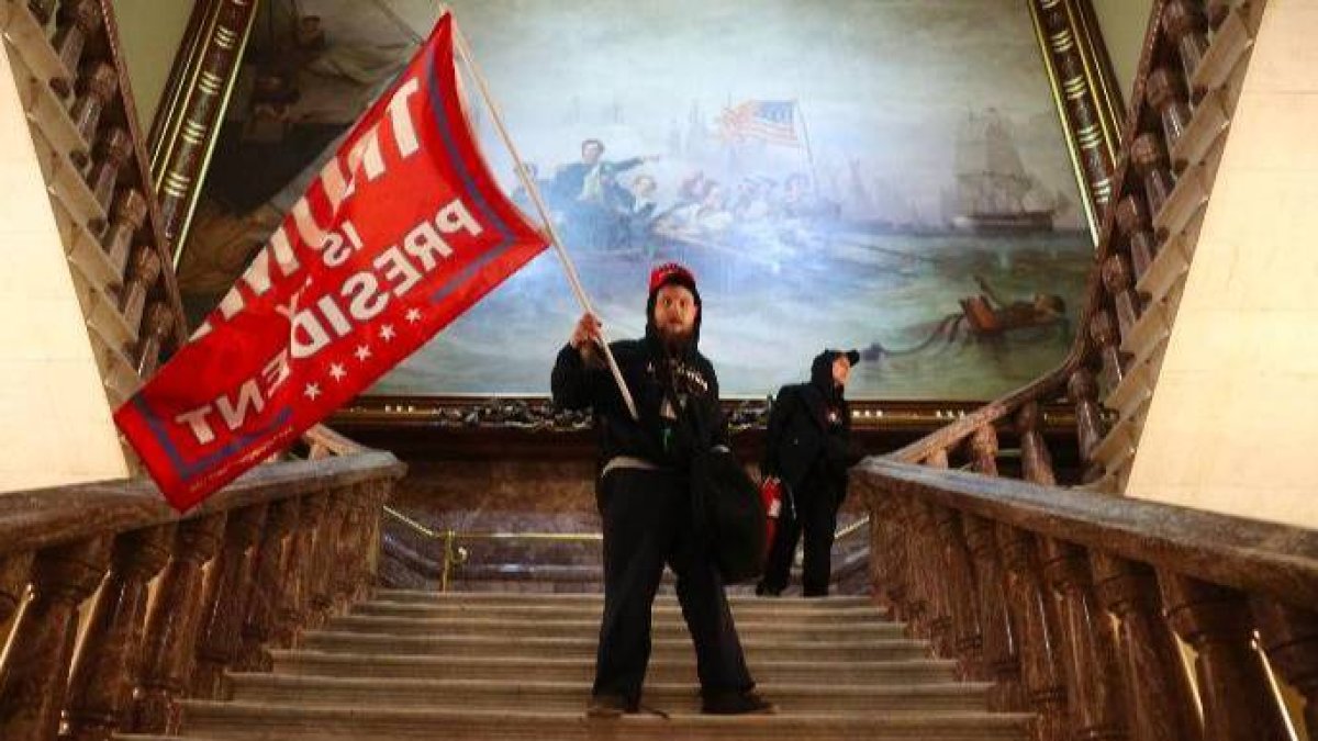 Un seguidor de Trump agita una bandera dentro del Congreso.