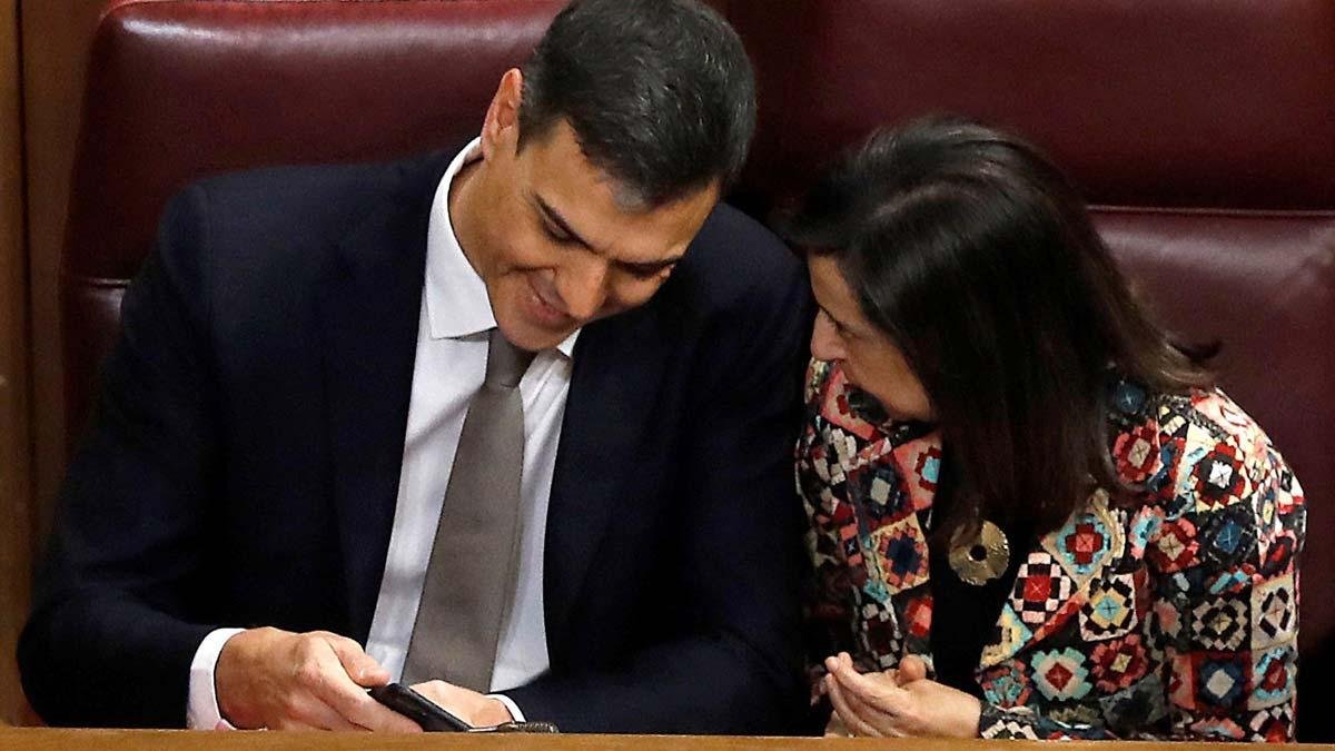 Pedro Sánchez y Margarita Robles ven el móvil