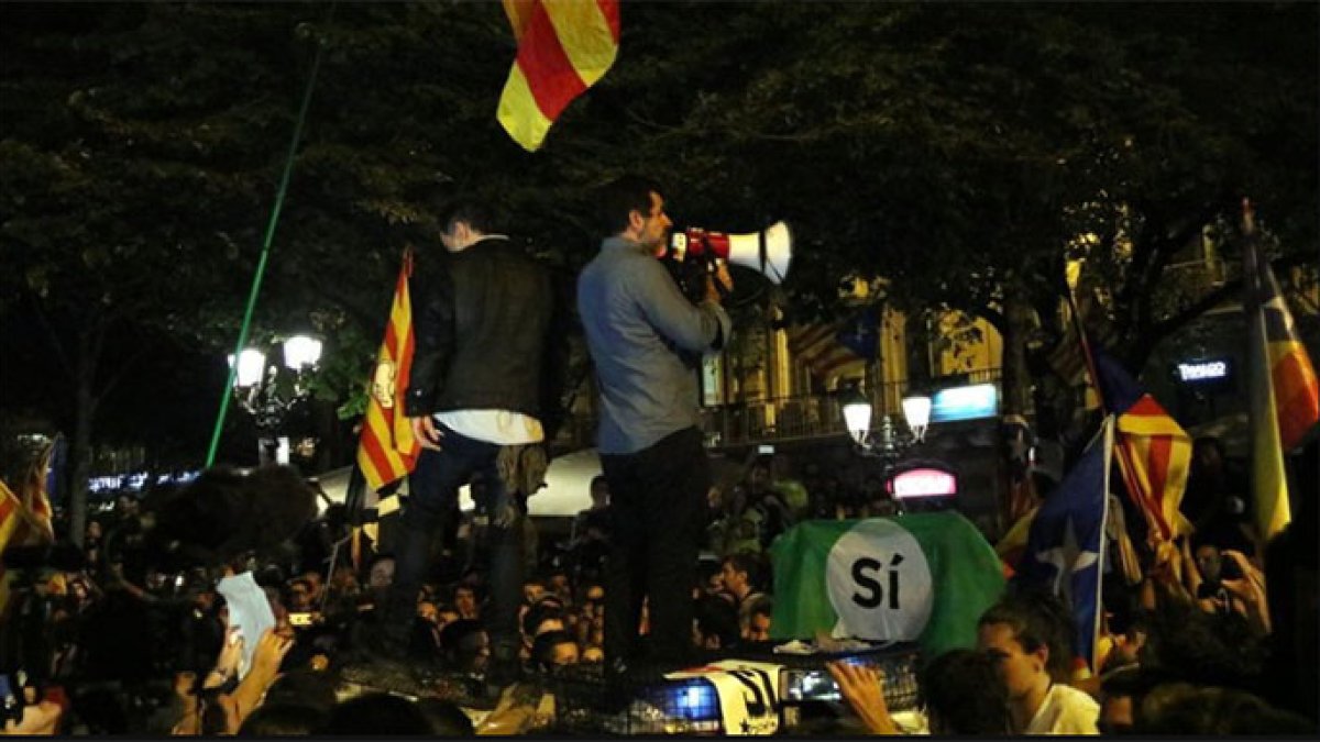 Los Jordis subidos a un vehículo de la Guardia Civil arengando a la multitud.