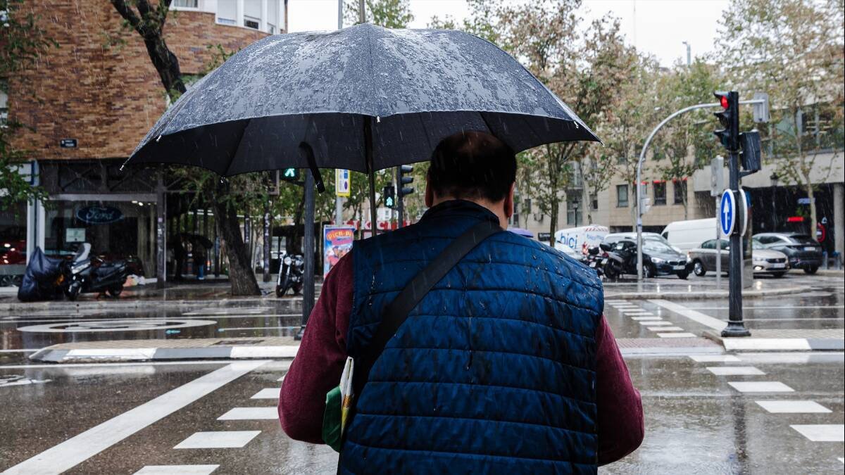 Un hombre se protege con su paraguas de la lluvia provocada por la borrasca Ciarán.