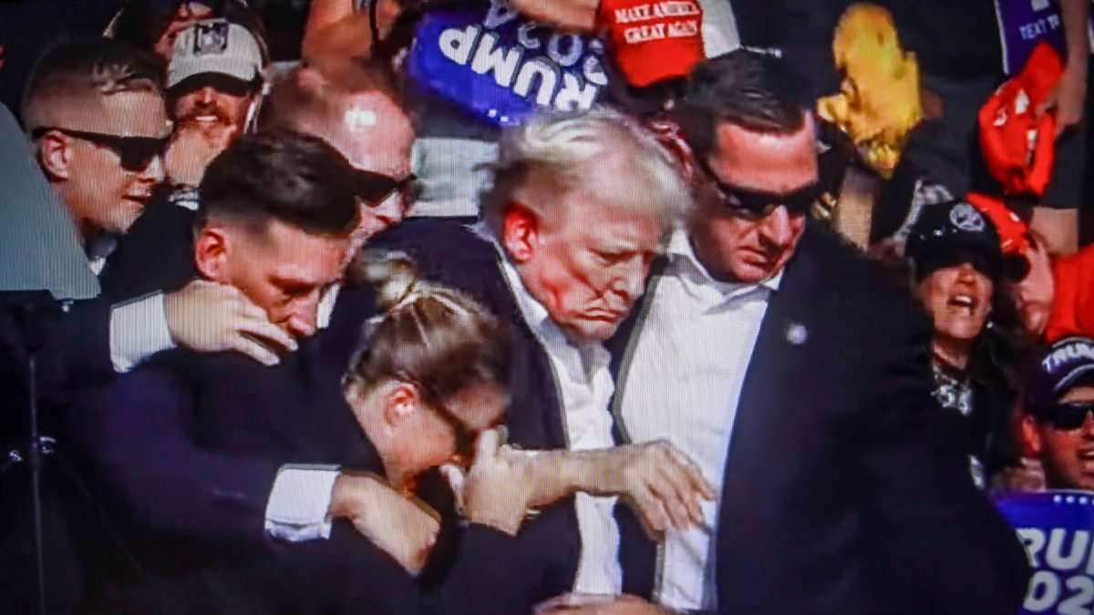 Donald Trump, con sangre en su oreja derecha, junto a sus guardaespaldas.