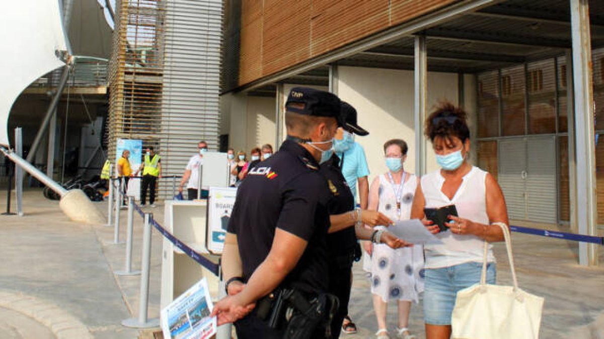 Agentes de la Policía Nacional explicando a los cruceristas la aplicación móvil de seguridad