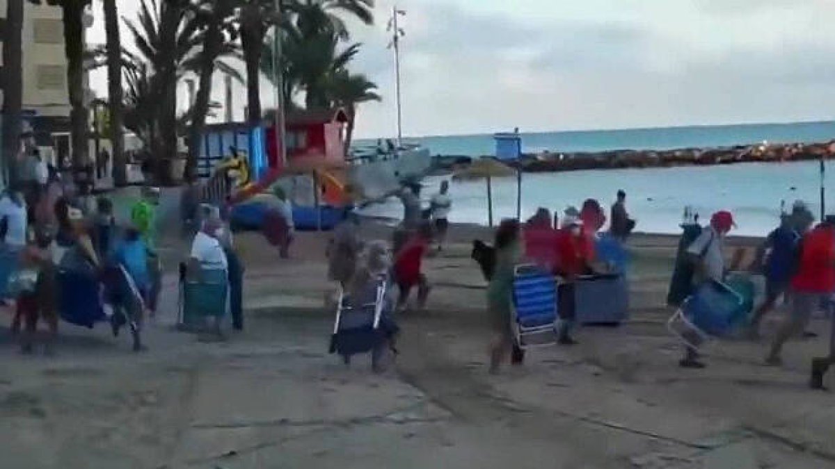 Decenas de personas en plena carrera para coger un sitio en la playa de Torrevieja