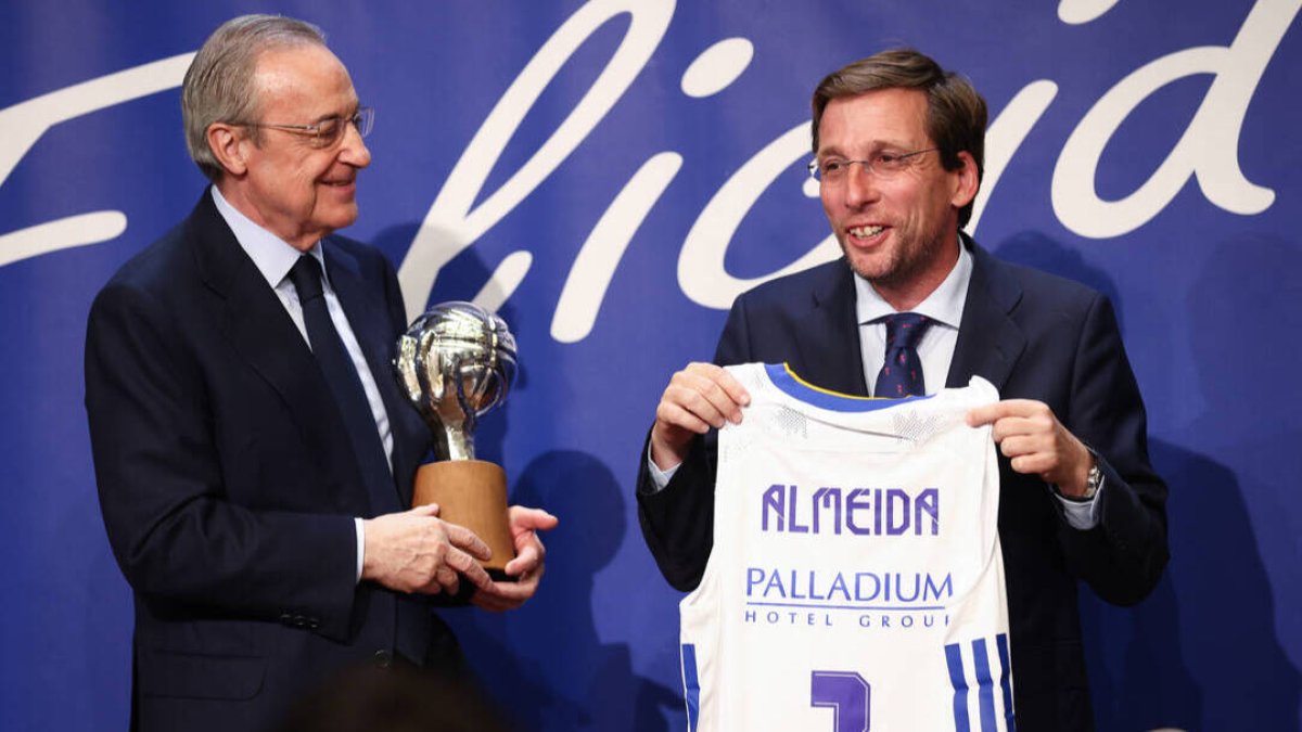 José Luis Martínez-Almeida recibe, de parte de Florentino Pérez, una camiseta del Real Madrid de baloncesto.